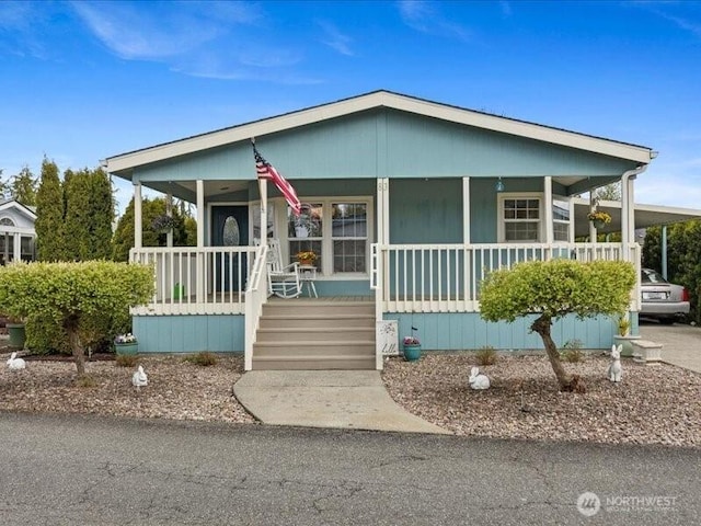 manufactured / mobile home featuring a porch and a carport
