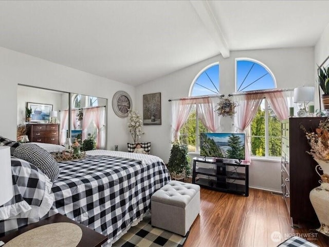 bedroom featuring vaulted ceiling with beams and wood finished floors