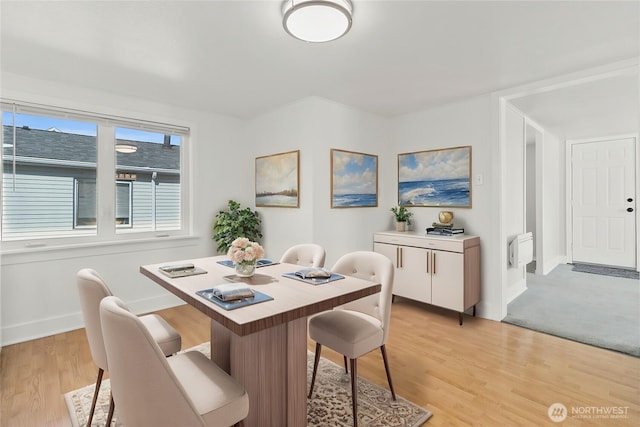 dining area featuring baseboards and light wood-type flooring