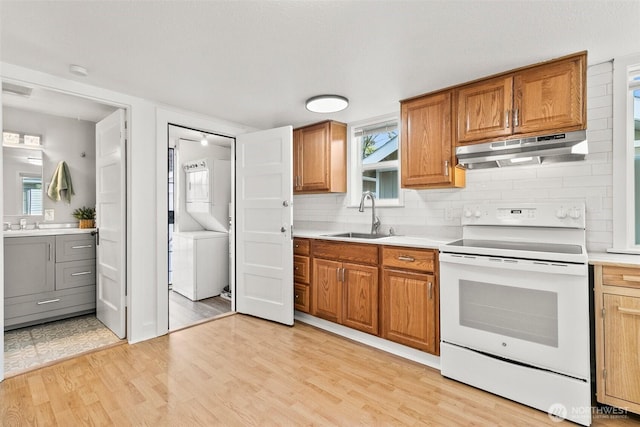 kitchen with light wood-style floors, a sink, under cabinet range hood, and white range with electric stovetop