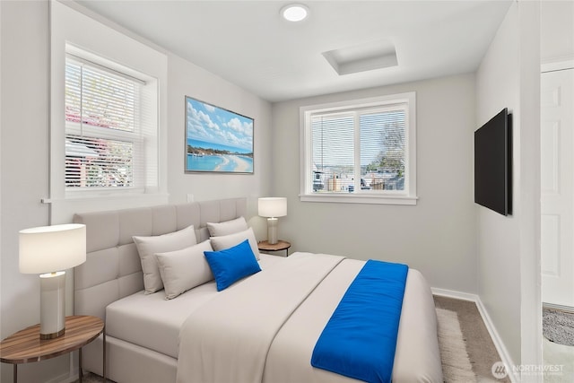 bedroom with baseboards, attic access, and carpet flooring