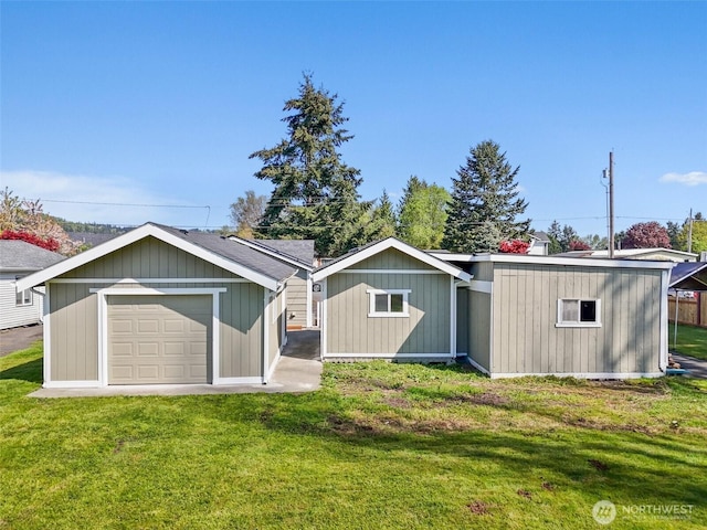 rear view of property with a lawn and a garage