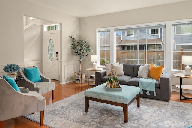 interior space featuring wainscoting, a healthy amount of sunlight, and wood finished floors