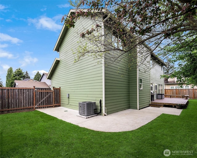 rear view of house with a fenced backyard, a patio area, a wooden deck, and a yard
