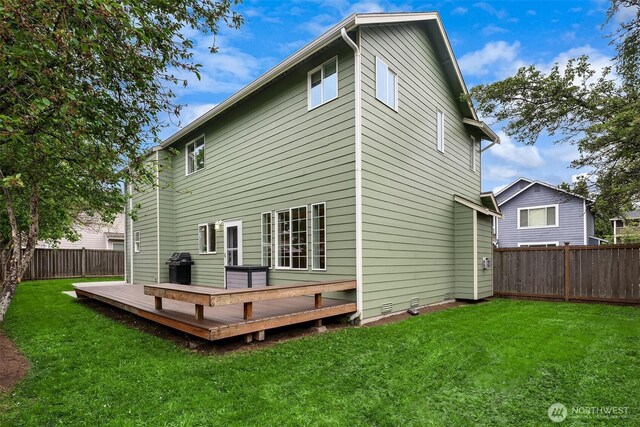 back of property featuring a fenced backyard, a yard, and a deck