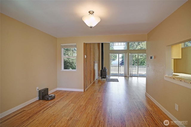 366 Tillicum Way, Camano Island, WA 98282 - interior space with baseboards, a wood stove, and light wood-style flooring