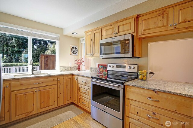 366 Tillicum Way, Camano Island, WA 98282 - kitchen with a sink, light wood finished floors, stainless steel appliances, and light stone counters