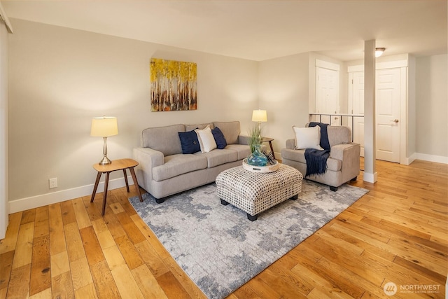 living area with wood-type flooring and baseboards
