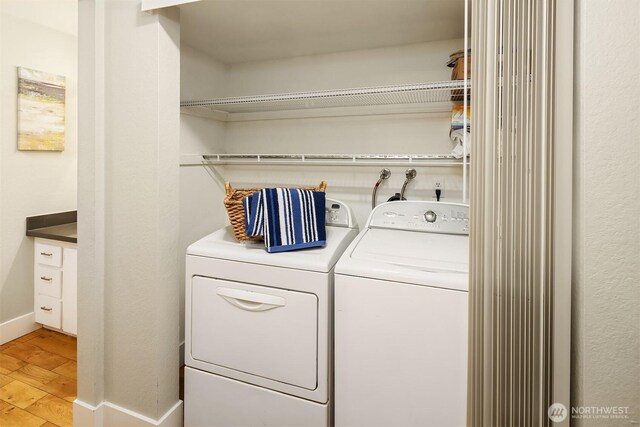 laundry room featuring light wood finished floors, independent washer and dryer, laundry area, and baseboards