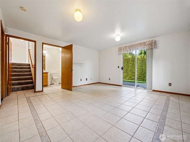 unfurnished room with baseboards, light tile patterned floors, and stairway
