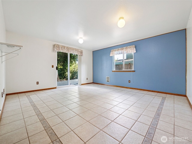 empty room with light tile patterned floors, baseboards, and visible vents