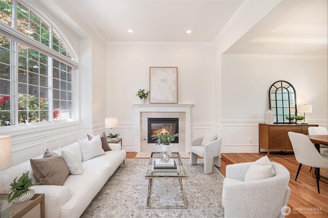 11628 NE 100th St, Kirkland, WA 98033 - living room featuring wood finished floors, ornamental molding, a tiled fireplace, wainscoting, and recessed lighting