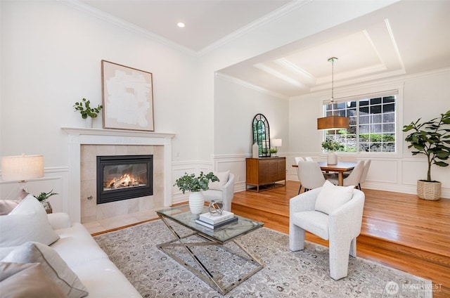 11628 NE 100th St, Kirkland, WA 98033 - living area featuring wood finished floors, a decorative wall, a tile fireplace, a raised ceiling, and ornamental molding