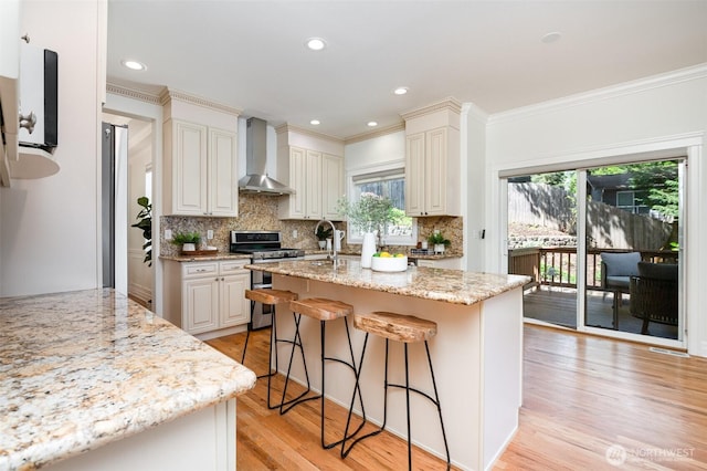 11628 NE 100th St, Kirkland, WA 98033 - kitchen featuring wall chimney exhaust hood, range with two ovens, plenty of natural light, tasteful backsplash, and crown molding