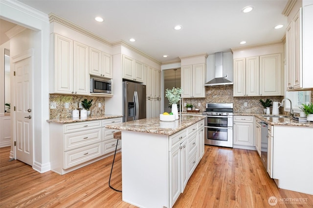 11628 NE 100th St, Kirkland, WA 98033 - kitchen featuring stainless steel appliances, wall chimney exhaust hood, a center island, decorative backsplash, and light wood finished floors