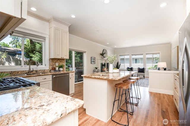 11628 NE 100th St, Kirkland, WA 98033 - kitchen featuring stainless steel appliances, light stone countertops, healthy amount of natural light, light wood-style floors, and recessed lighting