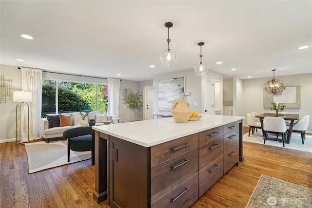 kitchen with light countertops, recessed lighting, decorative light fixtures, and wood finished floors