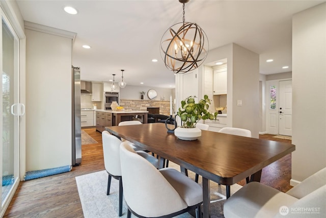 dining room featuring an inviting chandelier, baseboards, recessed lighting, and wood finished floors