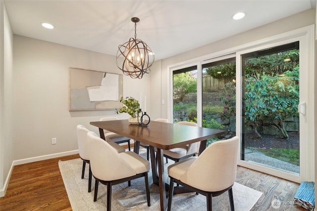 dining area with an inviting chandelier, baseboards, recessed lighting, and wood finished floors