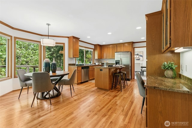 26006 NE 27th Dr, Redmond, WA 98053 - kitchen with appliances with stainless steel finishes, a kitchen breakfast bar, ornamental molding, and brown cabinetry