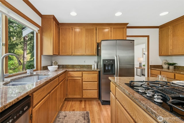26006 NE 27th Dr, Redmond, WA 98053 - kitchen featuring brown cabinetry, light stone counters, a sink, light wood finished floors, and appliances with stainless steel finishes