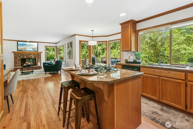 26006 NE 27th Dr, Redmond, WA 98053 - kitchen with a sink, light wood finished floors, a kitchen breakfast bar, a center island, and ornamental molding