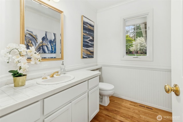 26006 NE 27th Dr, Redmond, WA 98053 - half bathroom featuring wainscoting, vanity, toilet, wood finished floors, and visible vents