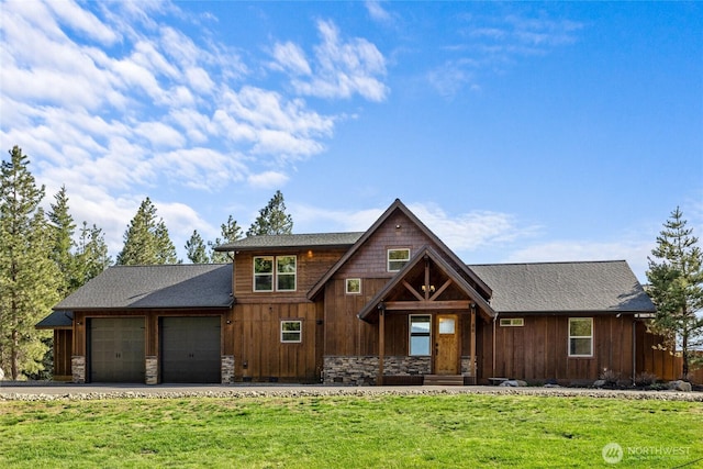 chalet / cabin featuring stone siding, a front yard, driveway, and an attached garage