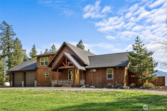 chalet / cabin with a front yard, stone siding, an attached garage, and fence