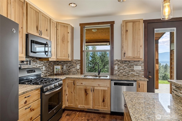 kitchen featuring a sink, a healthy amount of sunlight, stainless steel appliances, and light brown cabinets