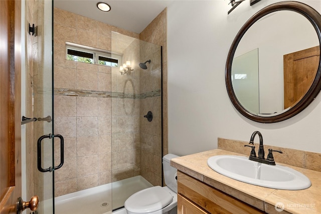full bath featuring toilet, a stall shower, and vanity