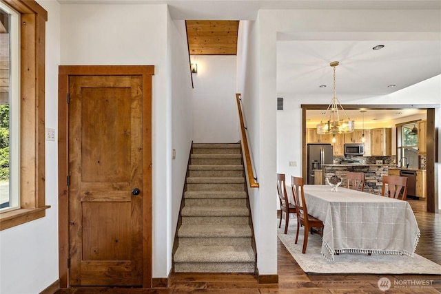 stairs featuring visible vents, recessed lighting, wood finished floors, and a notable chandelier