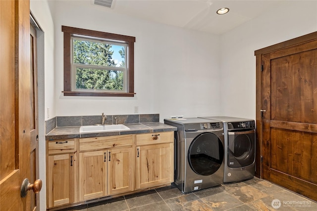 clothes washing area featuring a sink, visible vents, separate washer and dryer, cabinet space, and recessed lighting