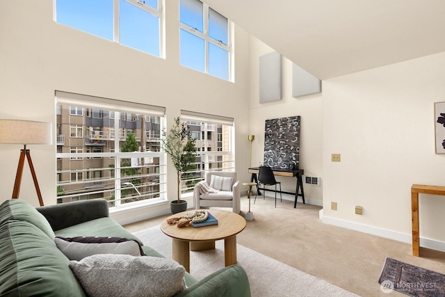 living room with baseboards, a high ceiling, carpet, and visible vents