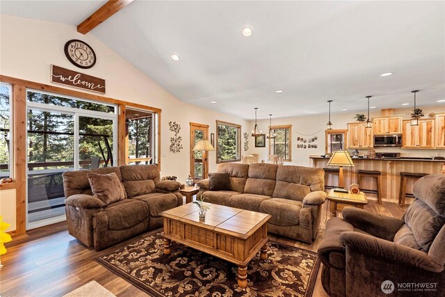 living area featuring recessed lighting, lofted ceiling with beams, dark wood-style floors, and a healthy amount of sunlight