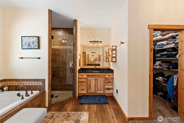 full bathroom with a shower stall, a walk in closet, and a garden tub