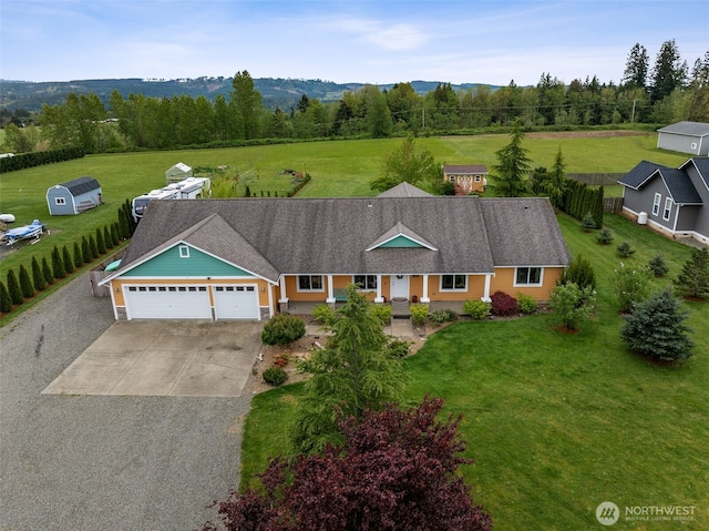 view of front of property featuring a mountain view, an attached garage, concrete driveway, and a front yard