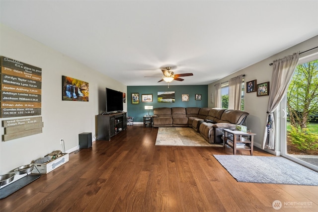 living room with a ceiling fan, wood finished floors, and a wealth of natural light