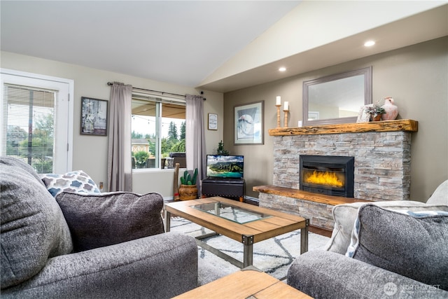 living area with wood finished floors, recessed lighting, a stone fireplace, and lofted ceiling