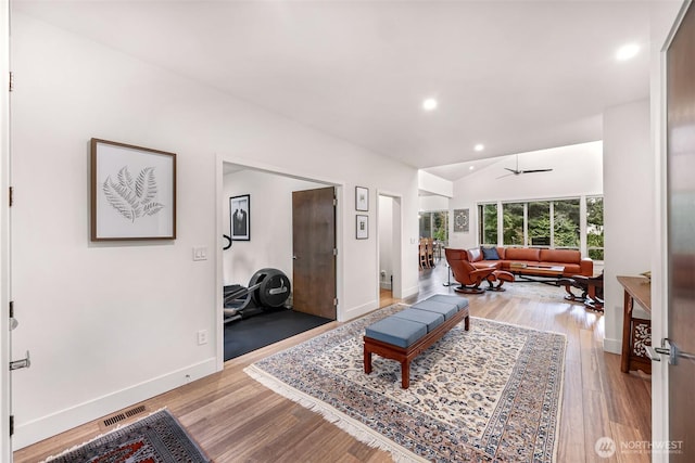 living area featuring baseboards, recessed lighting, a ceiling fan, light wood-style flooring, and vaulted ceiling