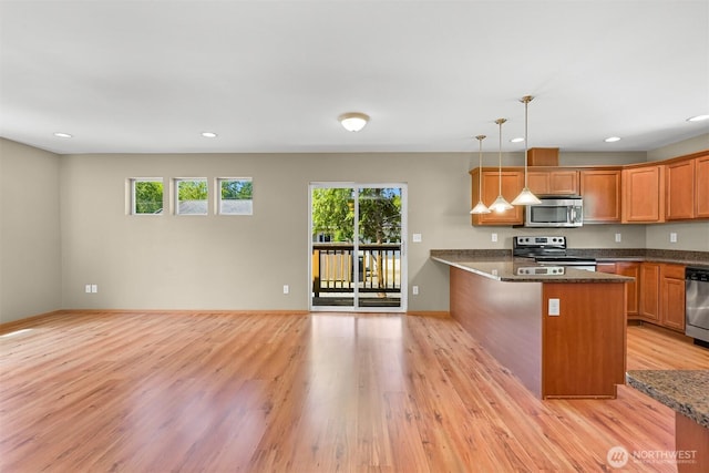 1321 Wilson Ave, Blaine, WA 98230 - kitchen featuring appliances with stainless steel finishes, light wood-style flooring, a peninsula, hanging light fixtures, and recessed lighting