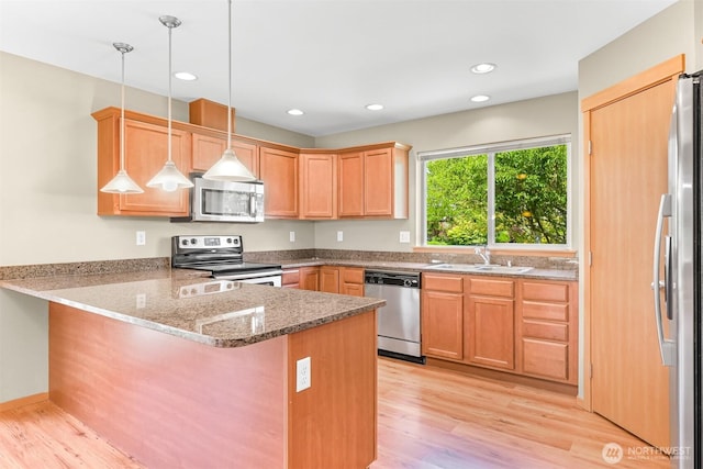 1321 Wilson Ave, Blaine, WA 98230 - kitchen featuring stainless steel appliances, a peninsula, light wood finished floors, stone counters, and recessed lighting