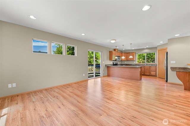 1321 Wilson Ave, Blaine, WA 98230 - unfurnished living room featuring light wood-style flooring, recessed lighting, a sink, and baseboards