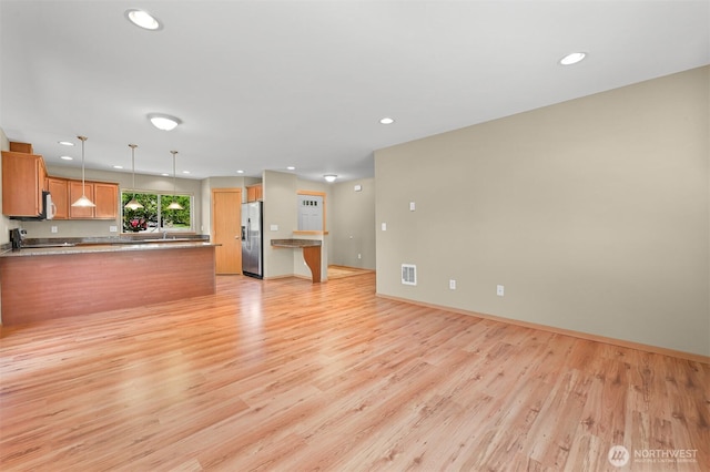 1321 Wilson Ave, Blaine, WA 98230 - unfurnished living room featuring recessed lighting, light wood finished floors, baseboards, and a sink