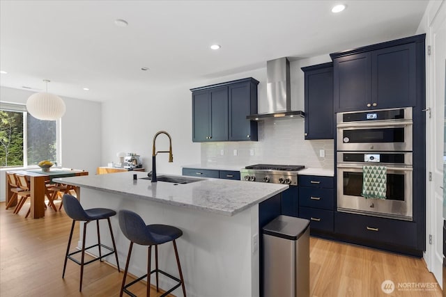 1616 96th Dr SE, Lake Stevens, WA 98258 - kitchen featuring wall chimney exhaust hood, a sink, an island with sink, stainless steel appliances, and a kitchen breakfast bar