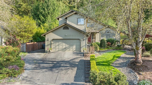 traditional-style home with fence, driveway, and a garage