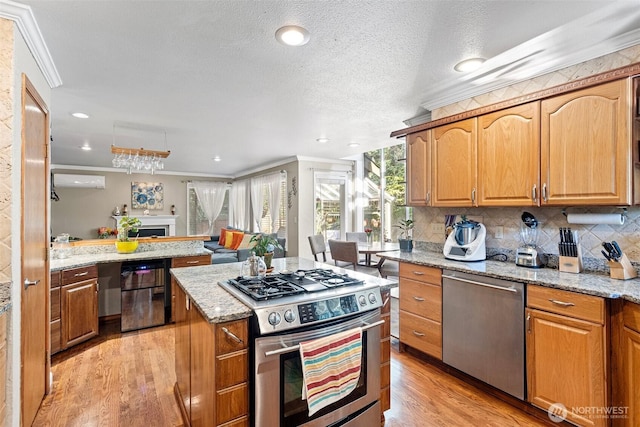 kitchen featuring light stone counters, appliances with stainless steel finishes, light wood-style flooring, backsplash, and ornamental molding