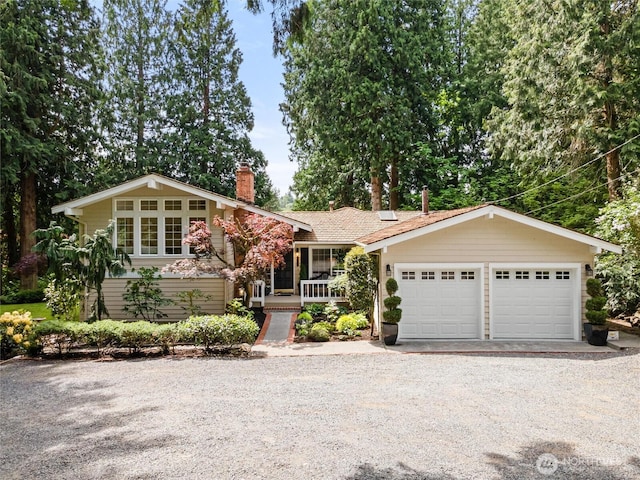 view of front of property with a chimney, driveway, and covered porch