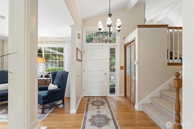 foyer with light wood-style floors, a chandelier, stairs, and baseboards