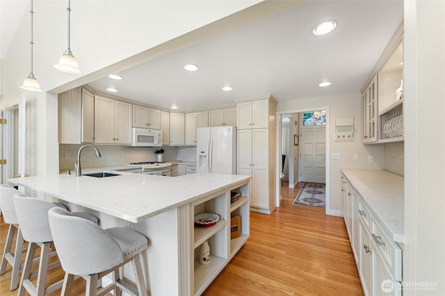 kitchen with white appliances, a sink, open shelves, a peninsula, and tasteful backsplash